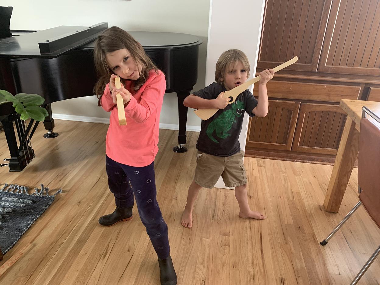 Kids posing with wood toy rifles.
